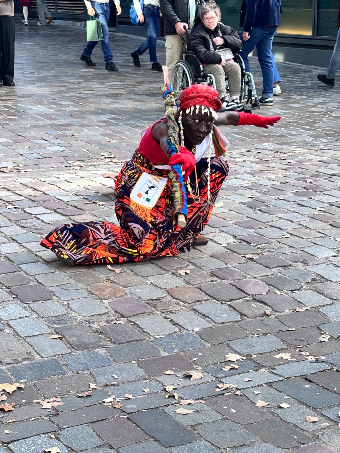 Kemet à genou sur les pavés, bras tendu